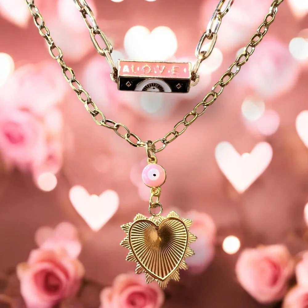 Gold toned chains with black, white, gold, and pastel pink enamel charms.